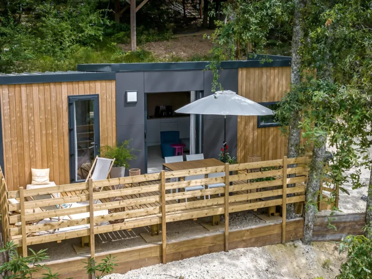 Chalet avec terrasse en bois sous les chênes, village de gîtes en Dordogne
